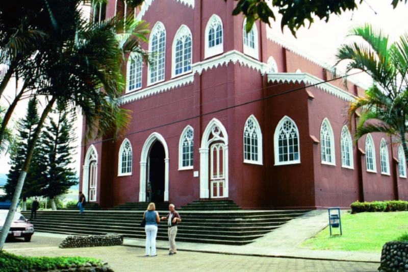 La gran iglesia de ladrillos y metal rojo en Grecia