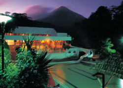  La piscina principal y tobogán en Tabacón con el Volcán Arenal creando su  propio clima